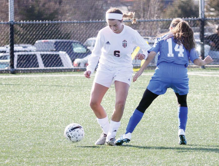 Stealing the ball from a forward, senior Whitney Simmons helps lead the Lions to a 2-0 victory over Pembroke Hill on March 25th at the season opener. Under a new head coach, the girls soccer team has thrived so far this season.