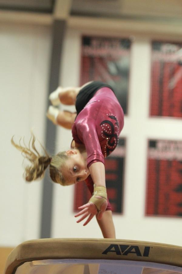 Flying through the air, senior Ashley Ammann competes in the vault at a meet hosted at LHS on Sept.11.
