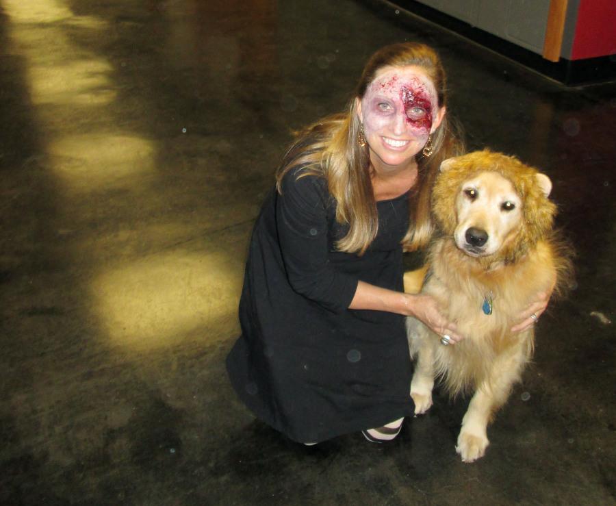 English teacher Keri Lauxman poses with her dog Roxy. Lauxman dressed as a zombie while Roxy came as a Chesty Lion.