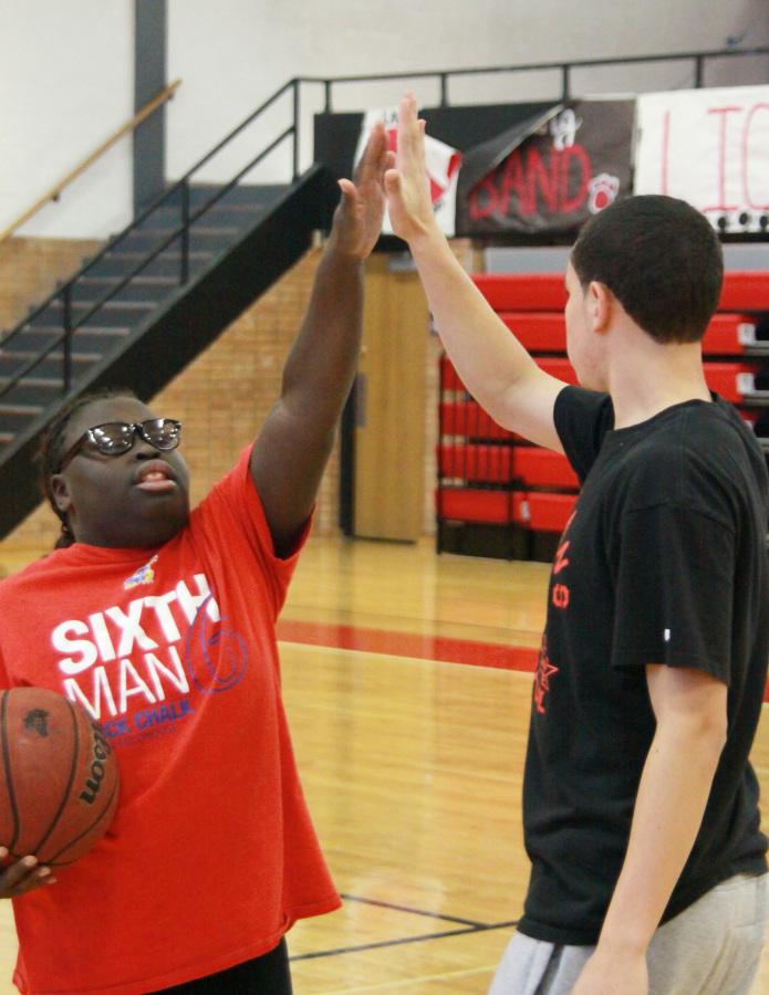 High-fiving at practice, juniors Ayesha Dunlap and Anthony Harvey practice after school for an upcoming Special Olympics basketball game. Students in the IPS classes are competing in the Special Olympics this year.