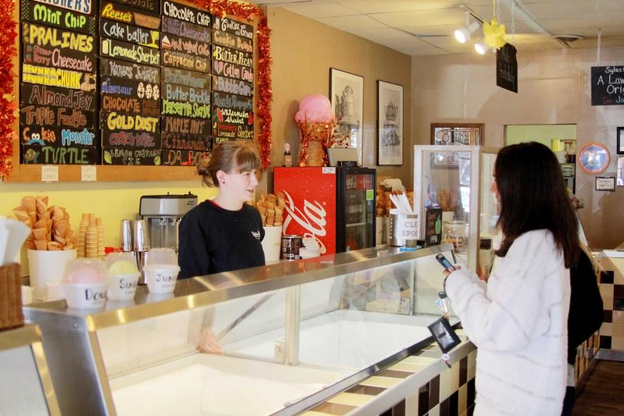 Talking with a customer, Sylas and Maddy’s employee Haley Ford stands behind the counter filled with original ice cream flavors.