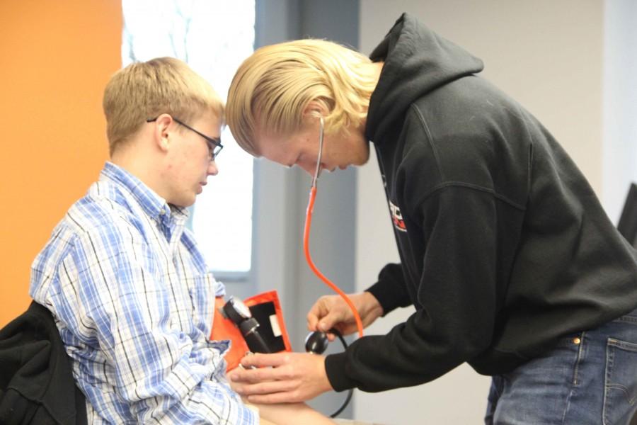 Senior Jaden Johnson checks a Free State student’s blood pressure in the EMS First Responder course offered at the College and Career Center.