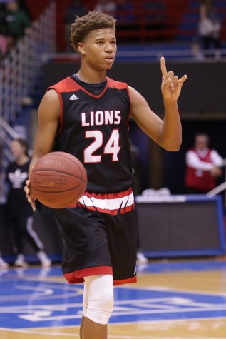 Sophomore guard Clarence King brings the ball up court, calling out a play during the game against Free State. The Lions won 61-57 during the matchup at Allen Fieldhouse last week.