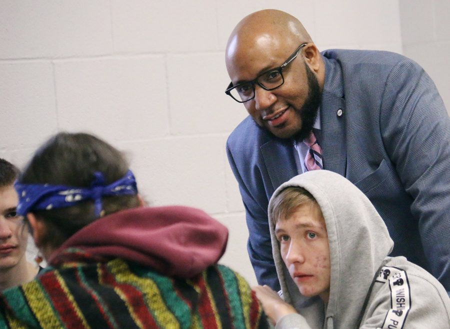 Superintendent Anthony Lewis leans in to talk to students before school Wednesday. USD 497 administrators flooded the rotunda during late arrival to provide an increased adult presence as the district works to respond to two recent incidents of students bringing guns to school as well as the investigation of a threat reported on Wednesday.