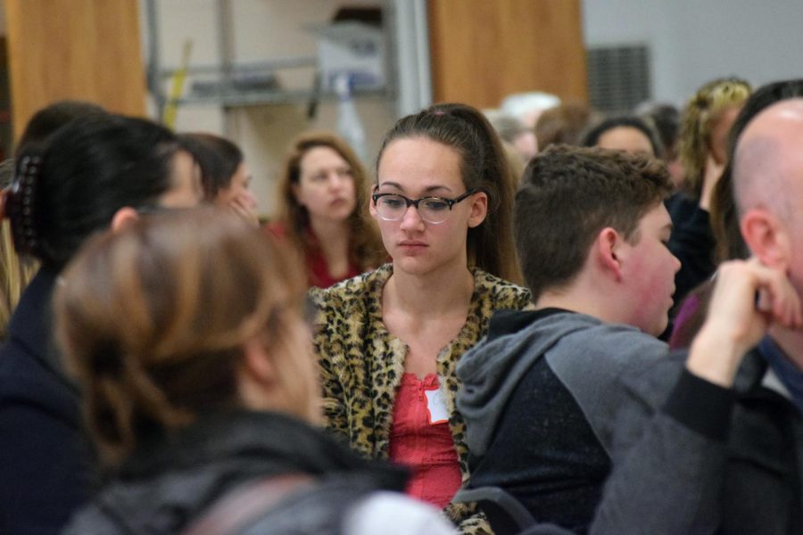 Junior Oscar Schmidt looks at the floor as fellow students, staff and parents within Lawrence Public Schools discuss the weapons brought to school, and possible solutions to improve student safety at the Community Safety Meeting held on Feb. 21.