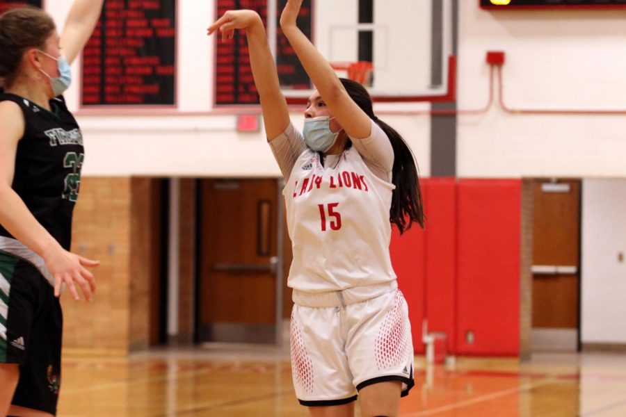Following through, junior Layla Harjo completes a three-pointer. 