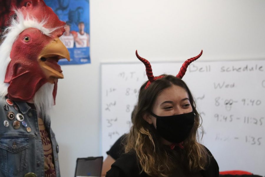 Taking part in an American tradition, exchange student Maria Szydlo trick or treats as a devil with classmate junior Maxwell Cowardin (dressed as a rooster).The journalism class trick-or-treated during fifth hour in November so Szydlo would have the experience after she was sick on Halloween. 