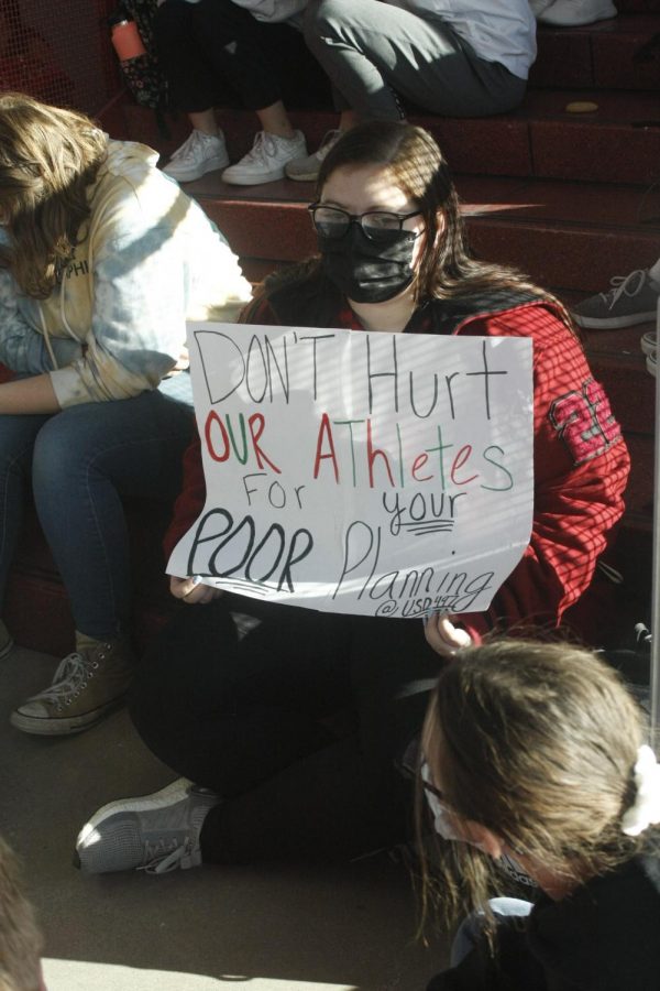 Senior Elaine Frink holds a sign while supporting the gymnastics team.