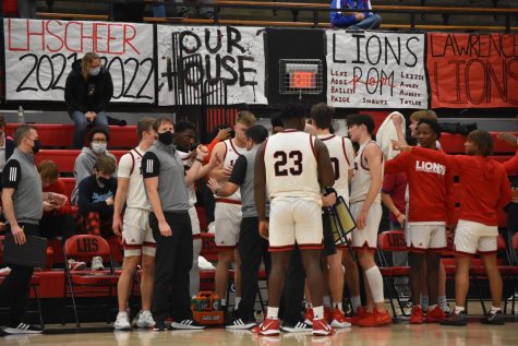 The boys basketball team huddles on the sideline after a timeout on February 4 in a game versus Shawnee Mission Northwest. The Lions defeated the Cougars 83-71. 