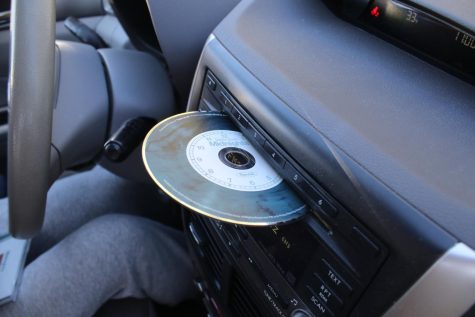 A disc of Taylor Swifts new album Midnights hangs out of a CD player.