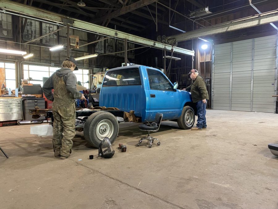 Ray and his grandfather work on their truck. 