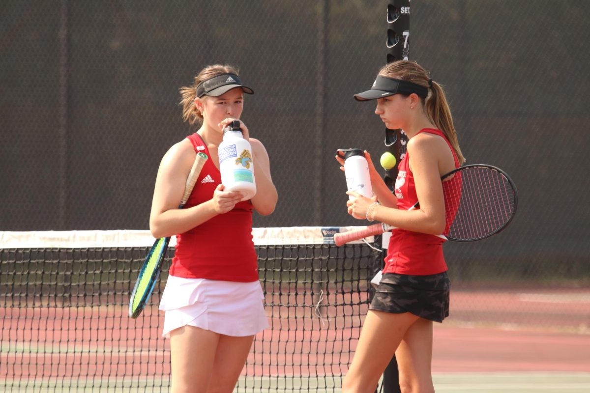 Juniors Harper Jay and Channing Saint Onge hydrate between matches to help deal with the heat early in the season.