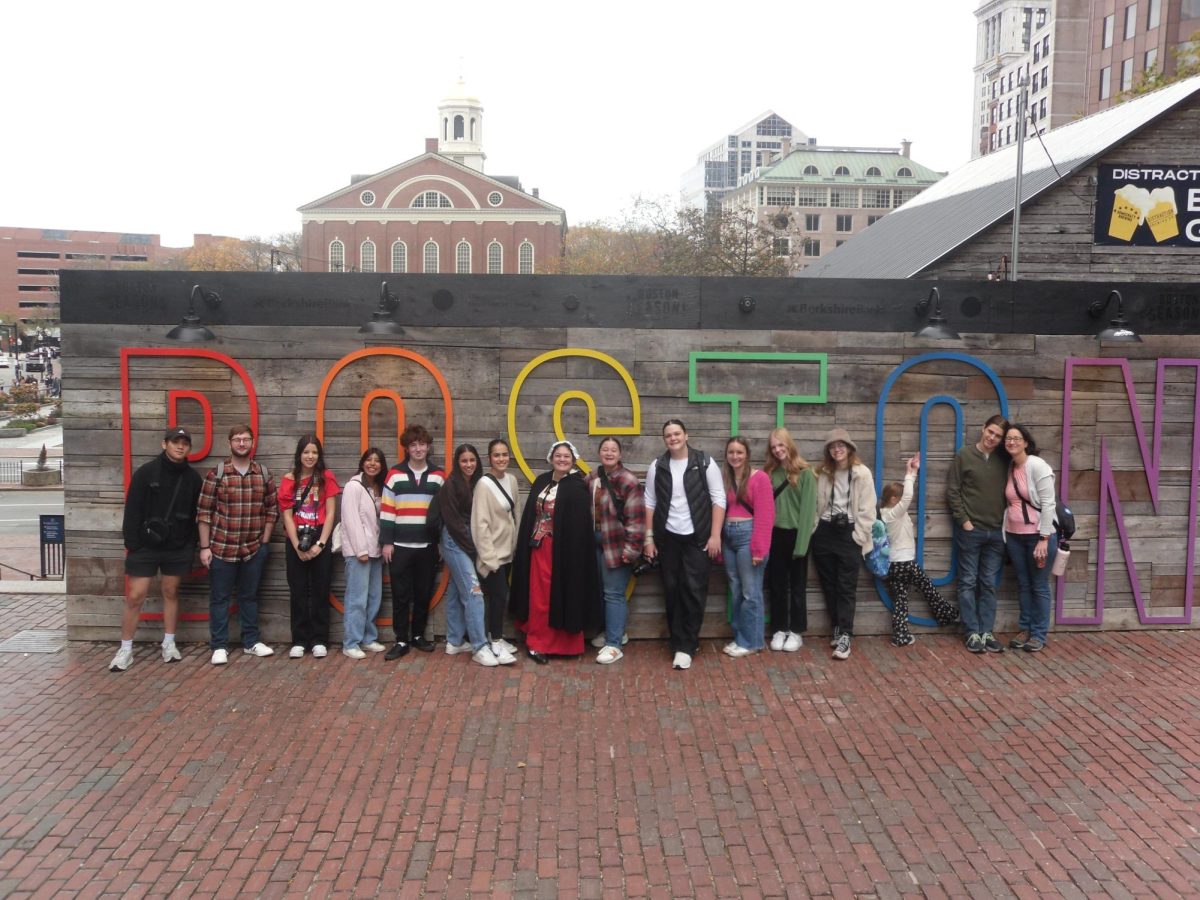 Lawrence High and Free State journalism students pose in front of the Boston sign.
