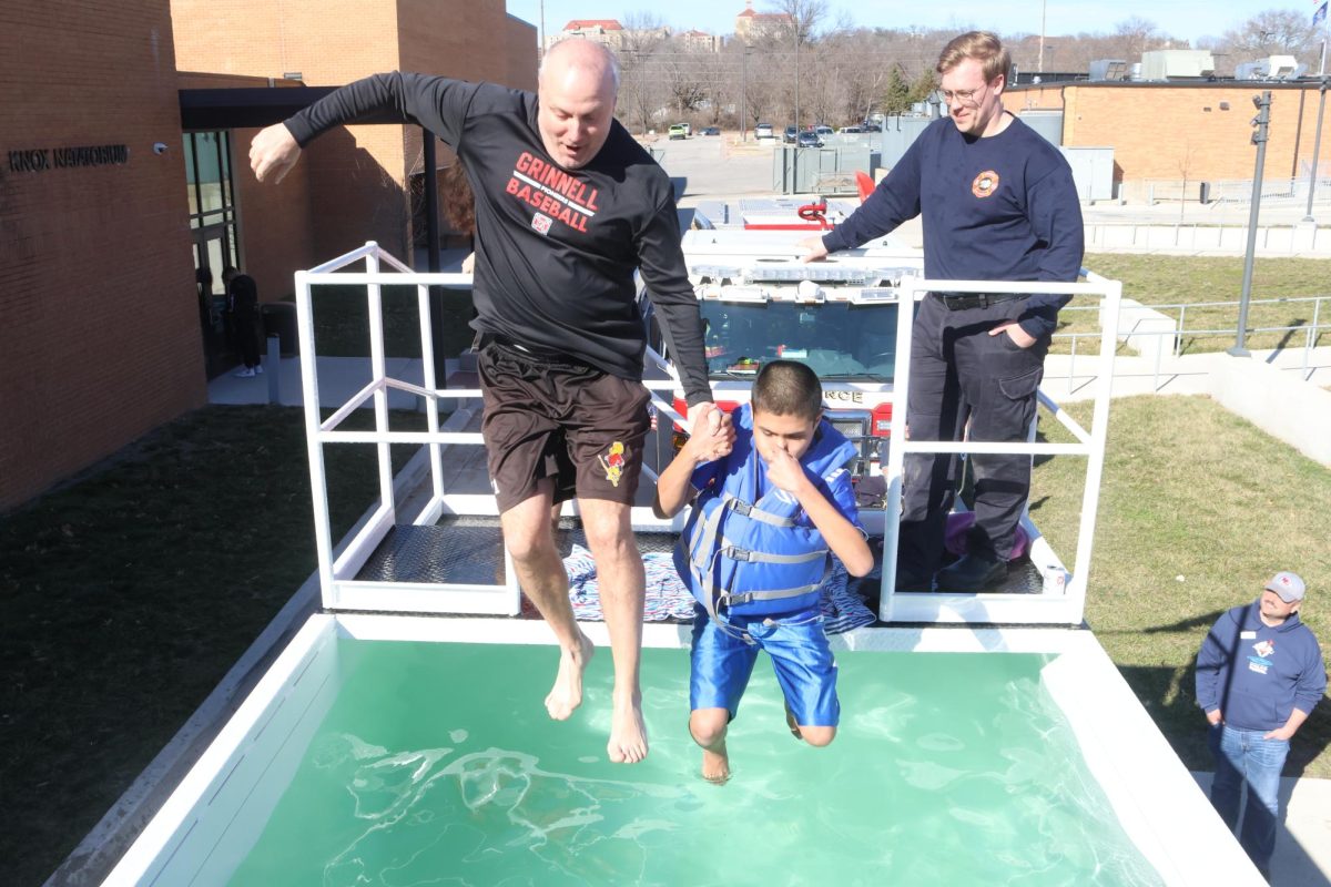 Brad Stoll and sophomore Richie Outcalt plunge together at the 2024 Polar Plunge fundraiser for Special Olympics.