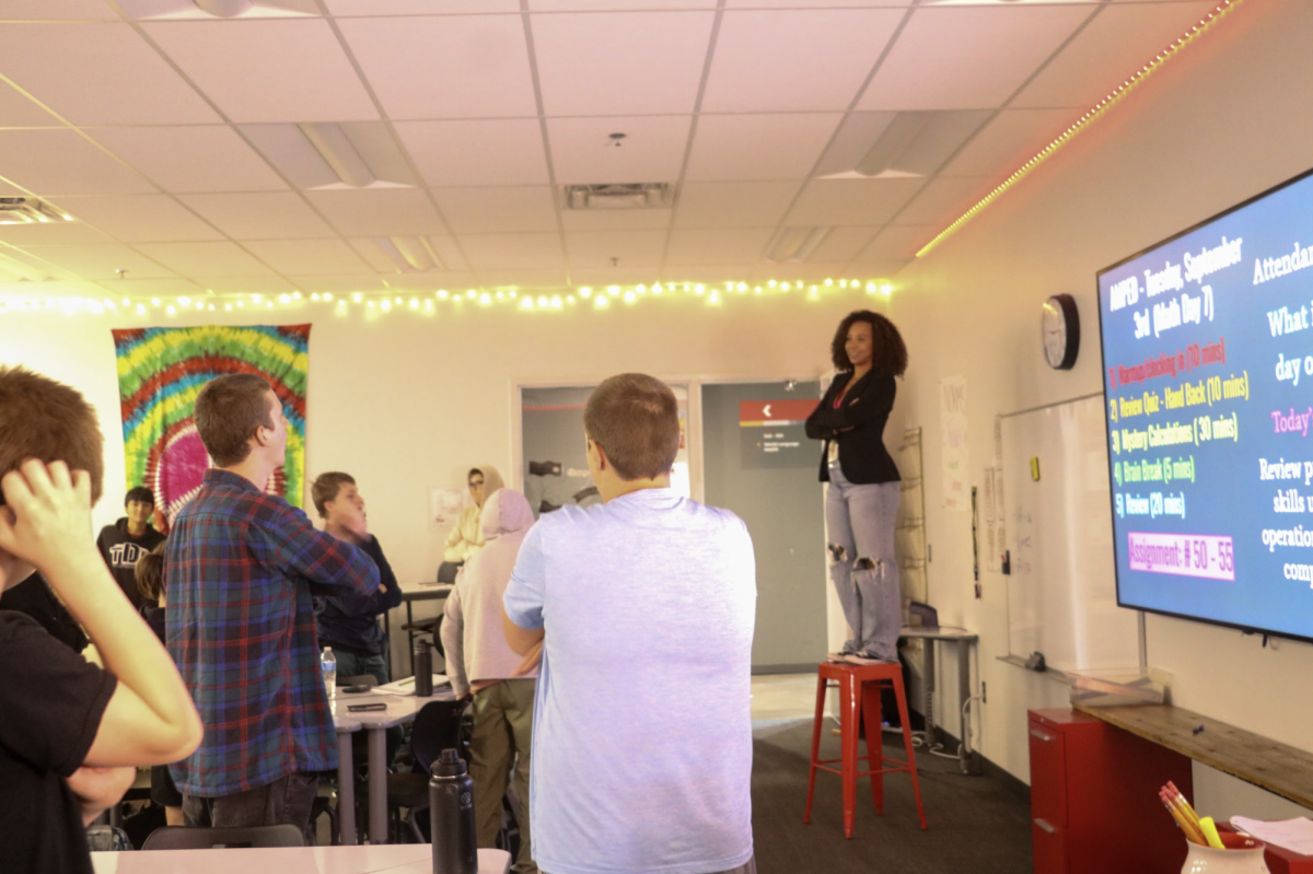 Standing on a chair to teach, Harrell gives instructions for an interactive activity. "It's a lot of fun," Harrell said. "The kids get an experience of learning math in a nontraditional way."